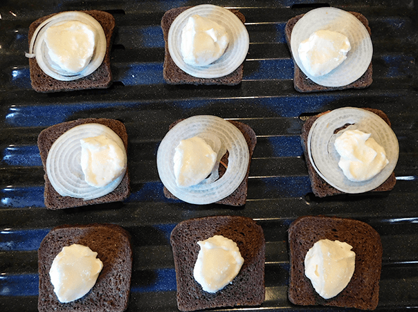 Pumpernickel Onion Toasties before cooking, on a broiler rack